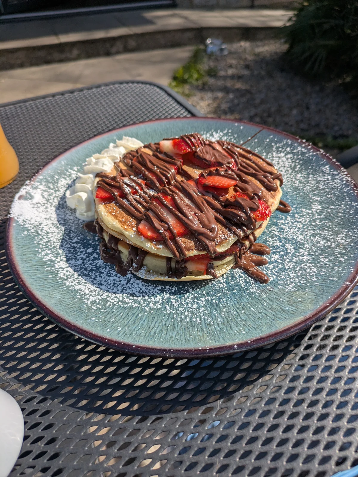 Chocolate-topped pancakes on a blue plate at Siam Corner